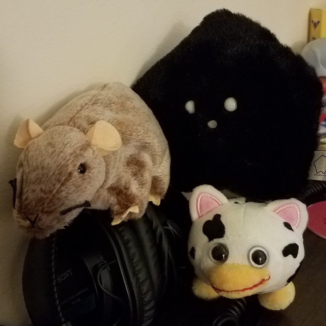 image of three plushes, one of a rat, one of a white star shaped blob and one that is indescribable