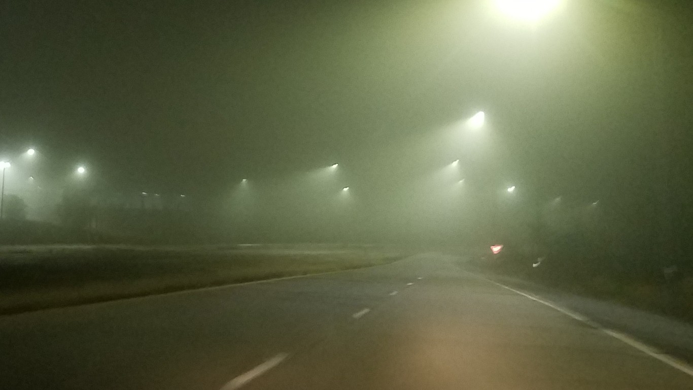 a foggy picture of an ominous road at night